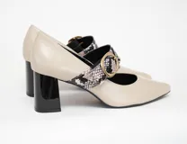 Zapato stiletto color arena con tira sobre el empeine con estampado animal print y hebilla dorada. Tacón bloque de 6,5 cm en color negro brillante.