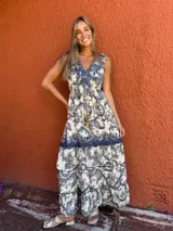 Vestido largo con estampado de cachemir en tonos crudo y azul, con escote en V y cintura ajustable con cordón. Presenta un panel liso en el ruedo.