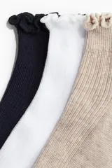 Pack de tres pares de medias cortas acanaladas, una negra, una blanca y una beige, con borde superior elástico y ribete sobrehilado.