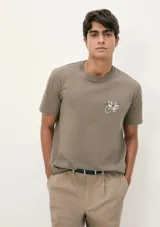 Camiseta blanca de algodón con cuello redondo y mangas cortas. Estampa rectangular con borde negro que contiene la frase "NATURAL ATMOSPHERE" en letras mayúsculas y una imagen de montañas y mar.