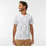 Remera blanca de manga corta con estampado de palmeras y paisajes en azul.
