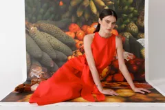 Vestido largo color rojo, sin mangas, con cuello redondo y lazo a la cintura.