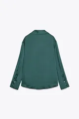 Camisa azul marino de satén con cuello solapa, escote en pico y mangas largas con puños abotonados.