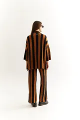 Conjunto tejido de saco y pantalón con rayas verticales en tonos marrón y negro. El saco es de corte recto con botones al frente y mangas 3/4. El pantalón es de corte palazzo.