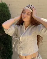 Collar corbatero con hilo de algodón natural color suela y dije de bronce macizo con forma de flores.