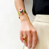 Anillo ancho de bronce con acabado martillado o texturizado, con una piedra natural ovalada engarzada en el centro.