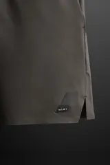 Shorts deportivos color gris oscuro confeccionados en tejido técnico ligero y elástico con forro interior, cintura elástica ajustable con cordón, bolsillos laterales, bolsillo de seguridad en espalda con cierre de cremallera, bajo con aberturas laterales y detalle de logo estampado en pernera.