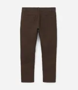 Pantalón de vestir marrón, de corte skinny, con bolsillos laterales y traseros. Se ajusta a la cintura con cinturón de cuero marrón.