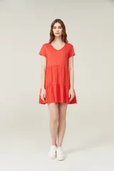 Vestido corto lila con cuello en V y mangas cortas. Tiene corte holgado y dos volados en la falda.