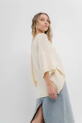 Sweater color crudo de tejido liviano con textura semi traslúcida, escote redondo y mangas amplias estilo murciélago.