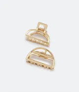 Set de dos pinzas para el pelo doradas, una con forma de semicírculo y otra rectangular con dientes. Fabricadas en metal.