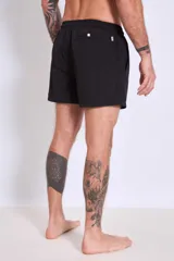 Short de baño color marrón con cordón ajustable en la cintura y logo estampado en blanco en la pierna izquierda.