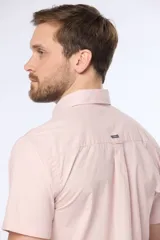 Camisa azul marino lisa de manga corta con cuello abotonado, cierre frontal con botones y bolsillo en el pecho. Confeccionada en algodón.