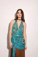 Vestido largo celeste con estampado abstracto multicolor, escote halter pronunciado, espalda baja y drapeado en la cadera. Incluye lazo para atar en el vestido o usar como bufanda.