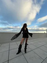 Minivestido negro de terciopelo con breteles finos y lazos colgando.