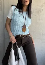 Chaleco celeste de hilo con diseño de trenzas.