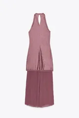 Vestido midi color lila, de cuello halter y sin mangas. La parte superior es de tejido arrugado y la falda es plisada. Tiene abertura en la espalda con cierre de botones ocultos.