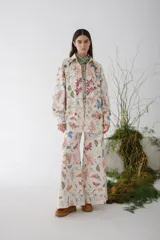 Camisa de manga larga con estampado de insectos y flores en tonos naranja, azul y rosa sobre fondo blanco.