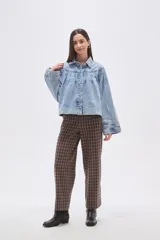 Campera de jean celeste con efecto lavado, caracterizada por mangas abullonadas y frunces en la zona del canesú, cierre frontal con botones metálicos y cuello camisero.