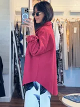 Chaqueta de jean oversize color rojo, con cuello clásico, cierre frontal con botones y mangas largas con puños abotonados.