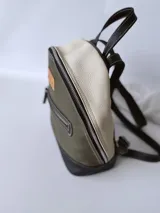 Mochila de cuero verde con detalles en blanco y negro.