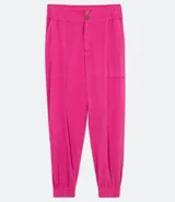 Pantalón jogger color crema de cintura alta con cierre y dos botones. Tiene elástico en la cintura, bolsillos aplicados y está confeccionado en viscosa.
