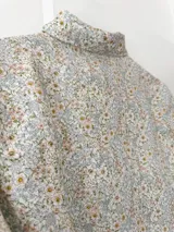 Camisa blanca estampada con flores pequeñas en tonos celeste, rosa y amarillo. Confeccionada en lino 100%, con botones de nácar y puntilla de algodón en los puños.