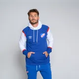 Canguro deportivo azul con capucha y mangas largas blancas, con detalles en rojo en los hombros y puños. Presenta el logo de Umbro y el escudo del Club Nacional de Football en el pecho. Incluye bolsillo tipo canguro y cordón ajustable en la capucha.