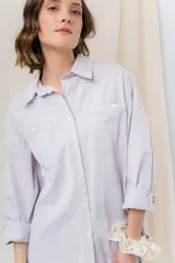 Camisa color crema de algodón liviano, calce oversize, con cuello camisero, cierre abotonado, mangas largas con opción de arremangado y dos bolsillos frontales con solapa.