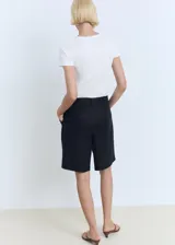 Remera blanca de algodón con cuello redondo y logo 'Mango' estampado en color dorado en el centro del pecho.