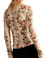 Blusa térmica color crema con estampado floral en tonos rojos y verdes, de mangas largas con puños acampanados.