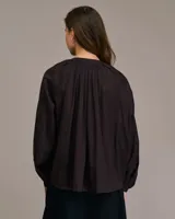 Blusa marrón con cuello mao y mangas largas abullonadas.