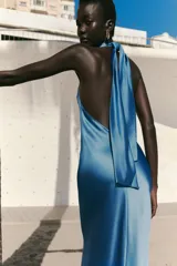 Vestido largo de satén color celeste, con cuello halter y espalda descubierta. Cierre trasero con cremallera oculta.