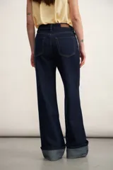 Pantalón de jean azul oscuro, de corte acampanado y tiro alto.