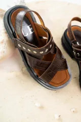 Sandalias negras de charol con tiras cruzadas y plataforma track.