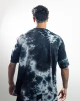 Remera negra con efecto tie-dye y logo pequeño en el centro del pecho.