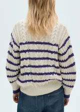 Sweater de punto grueso color crudo con rayas horizontales color violeta.