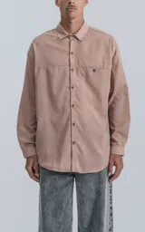 Camisa manga larga rosa con bolsillo con ojal y botón en delantero, de calce oversize confeccionada en textil plano fresco y liviano.