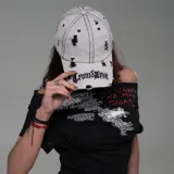 Gorra de béisbol color gris claro con efecto desgastado y roturas. Presenta bordado frontal con el nombre de la marca "Cromszron" en letras negras.