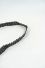 Cartera bandolera de cuero marrón oscuro con solapa y correa fina ajustable.