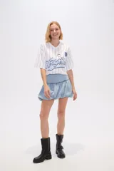 Minifalda de jean celeste con frunces en la cintura y ruedo abullonado.