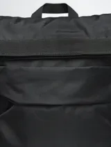 Mochila color beige con cierre superior enrollable y hebilla de ajuste.