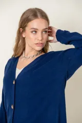 Cardigan celeste de lana con escote en V y botones marrones.