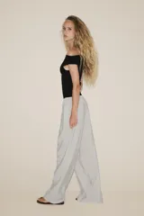 Pantalón palazzo color verde oliva de tejido fluido, tiro medio, cintura elástica ajustable con cordones y bolsillos laterales.