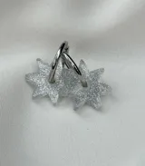 Par de aros plateados con dije en forma de estrella transparente con glitter.