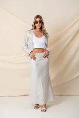 Pollera larga plateada con apliques metálicos y cintura elastizada.