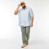 Camisa celeste de lino con cuello clásico, manga corta y cierre frontal con botones.