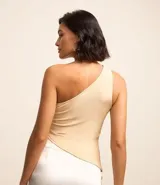 Blusa color beige claro, de poliéster y elastano, con escote asimétrico de un solo hombro, sin mangas, con fruncidos laterales y bajo asimétrico.