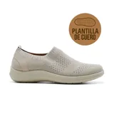 Zapatilla slip-on color beige, de tejido de punto calado, con plantilla de cuero y suela gruesa.