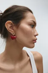 Aros colgantes con forma de corazón, con un corazón pequeño dorado en la parte superior y un corazón grande rojo en la parte inferior.